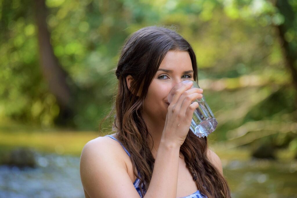 A woman drinking a glass of water.