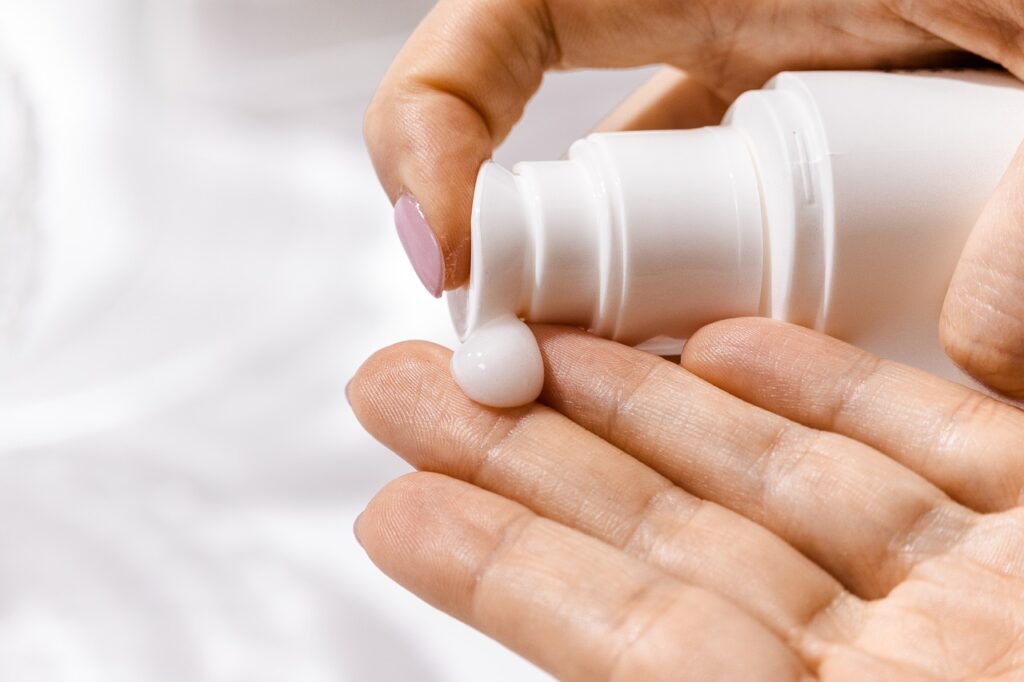A woman applying moisturiser.