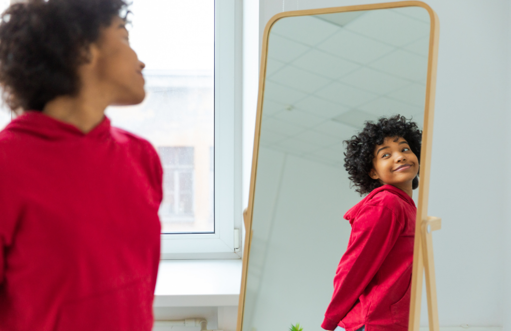 A woman smiling at herself in the mirror.