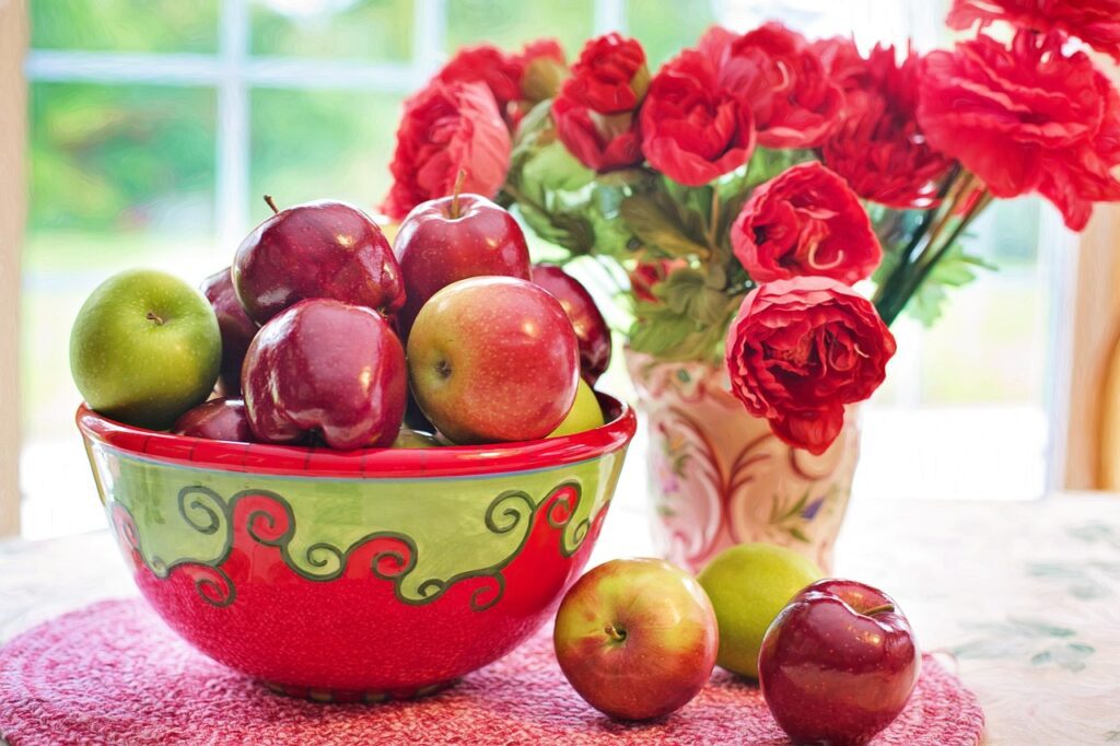 A bowl of apples on a table.