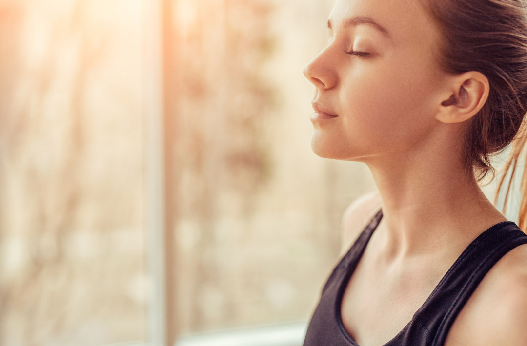 A woman taking a deep breath to promote relaxation, fight stress, and maintain good mental health.