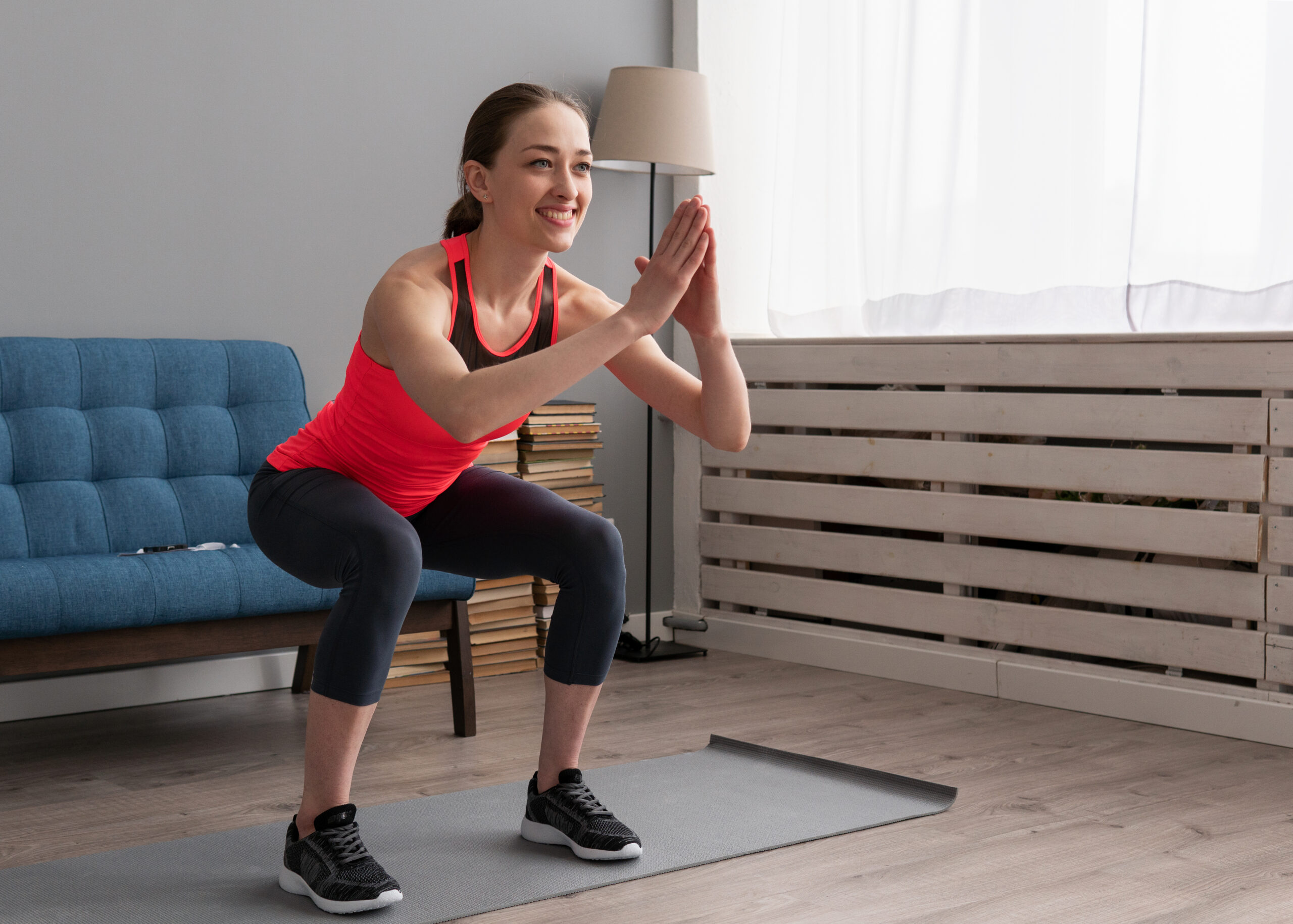 A lady performing a squat as an exercise at home.