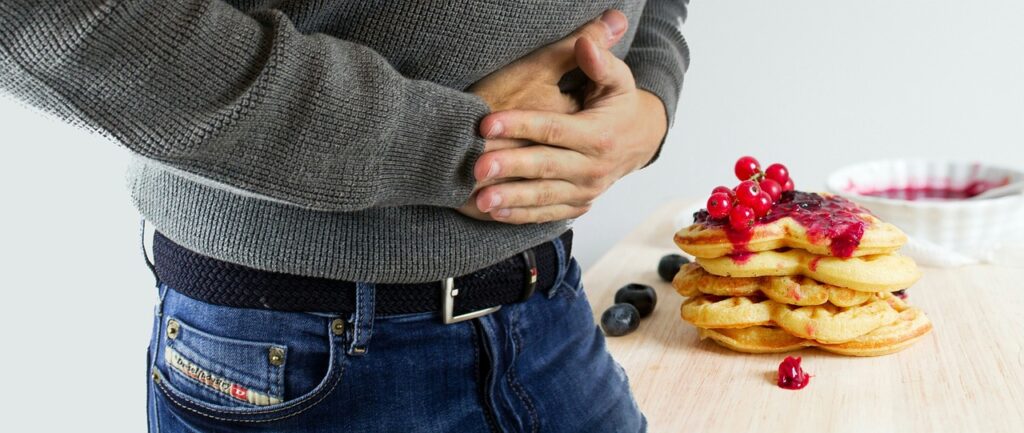 A man holding onto his stomach in pain.