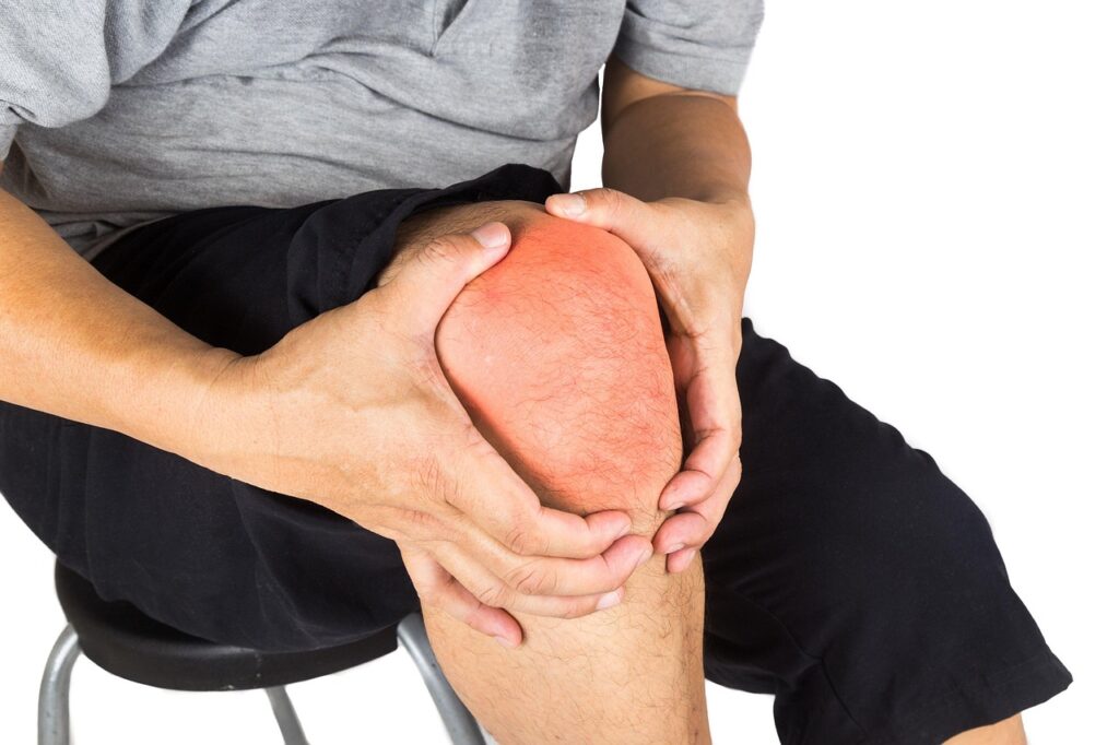 A man holding his knee in pain.