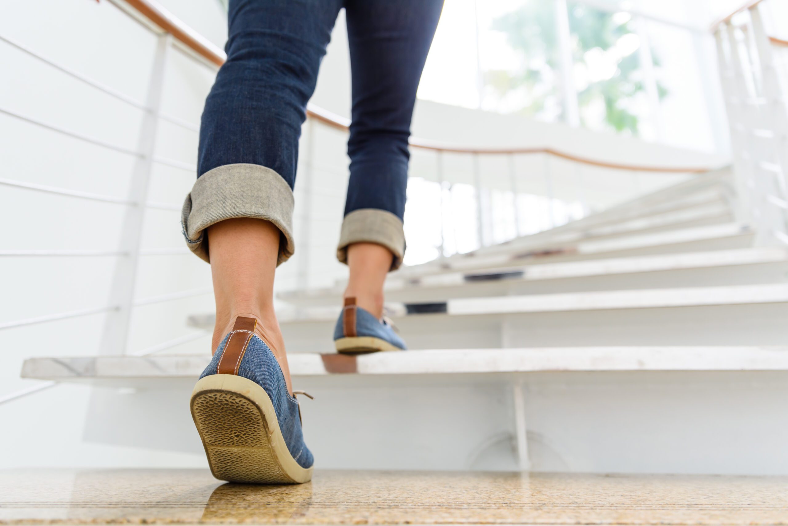 A young woman walking up some stairs to illustrate getting more movement into the day without even noticing it.