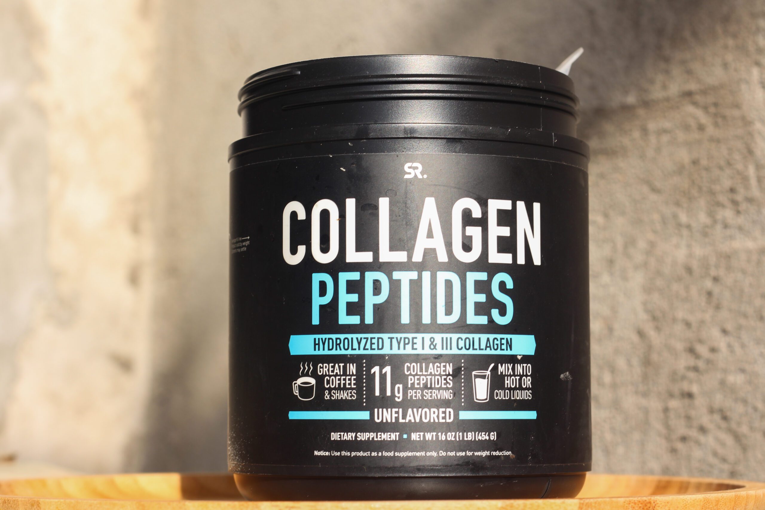 A black tub of collagen peptides supplement.