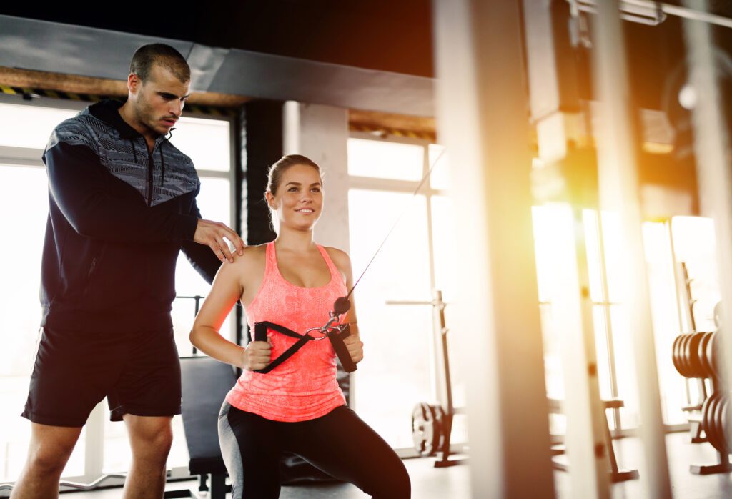 A woman doing resistance training in a gym to preserve lean muscle over fat.