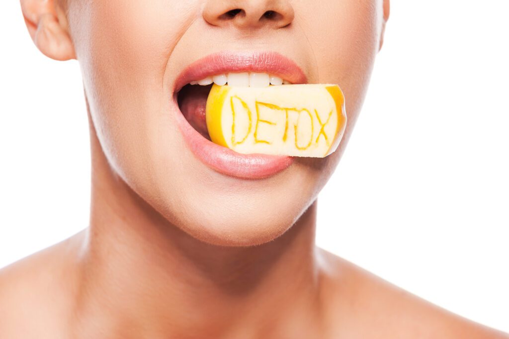 A woman biting a lemon that says detox